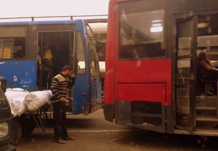 Hombre con carretilla entre buses Curiosidades de Egipto